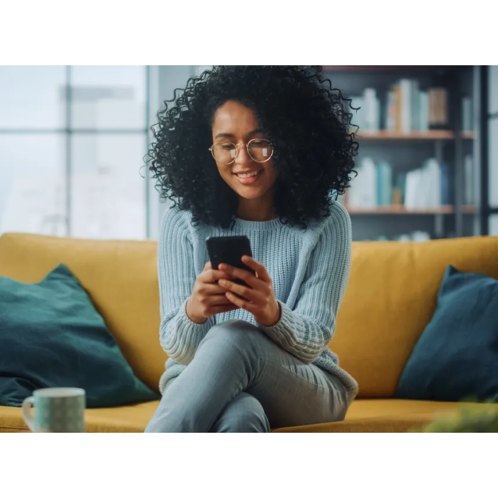Woman holding phone on the couch 